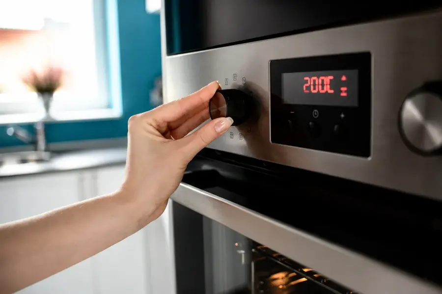 Hand adjusting oven dial